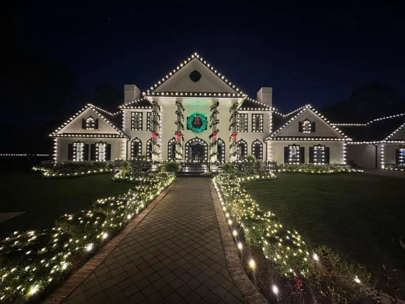 Palatial estate with a large wreath over the door and a light-lined pathway